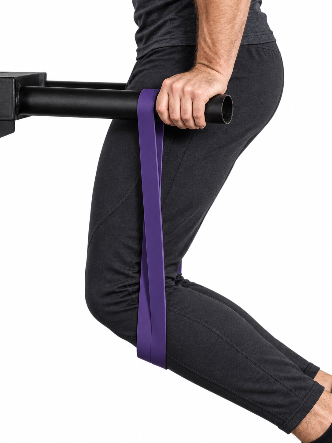 Athlete using a plain purple resistance band anchored over a bar during a lower-body stretch.